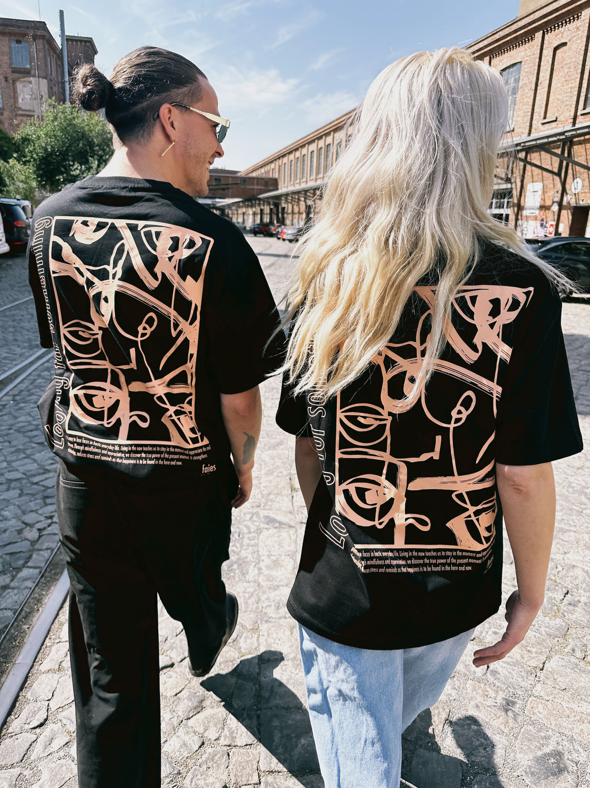 Schwarzes oversized T-Shirt mit weißem Continuous-Line-Print eines Gesichts auf dem Rücken und „faies“-Signatur – moderne Kunst trifft auf minimalistischen Streetstyle.