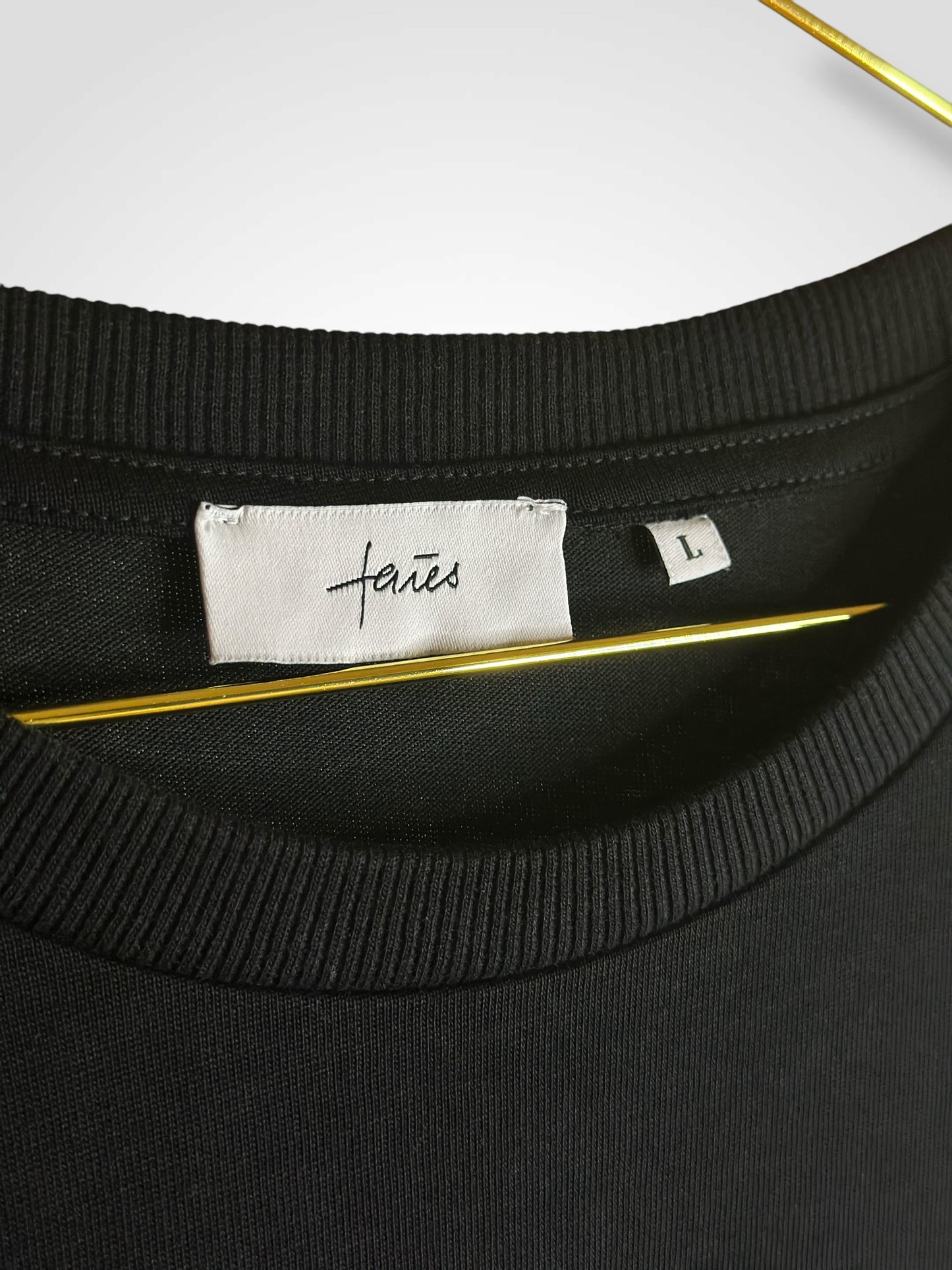 Schwarzes oversized T-Shirt mit weißem, abstrakten Gesichtslinien-Design auf dem Rücken und „faies“-Schriftzug – minimalistischer Streetwear-Stil auf schwarzem Hintergrund.